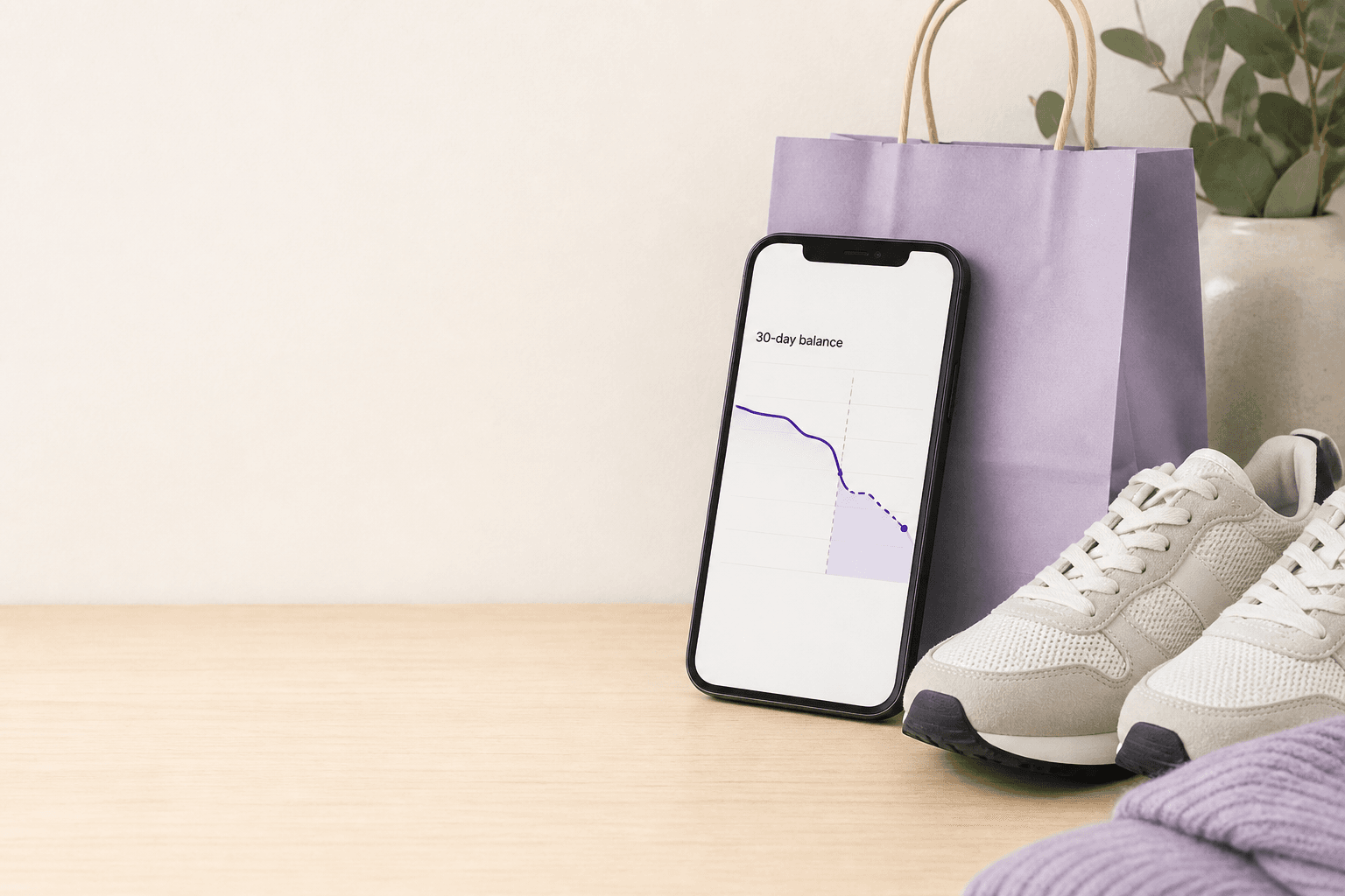 A planned purchase next to a phone showing a 30-day balance dip before buying